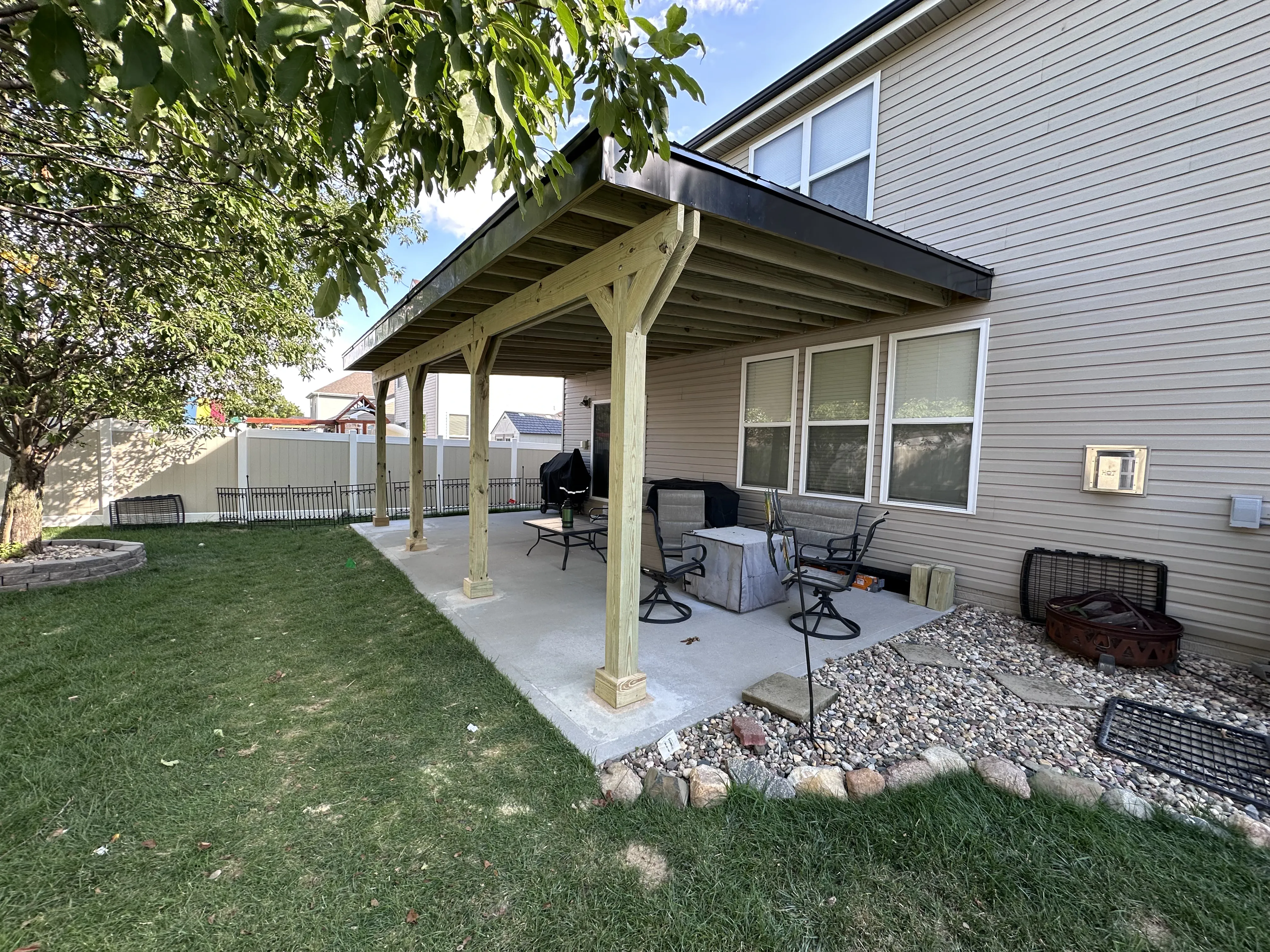 Covered patio with cedar posts and a slant roof over a concrete patio