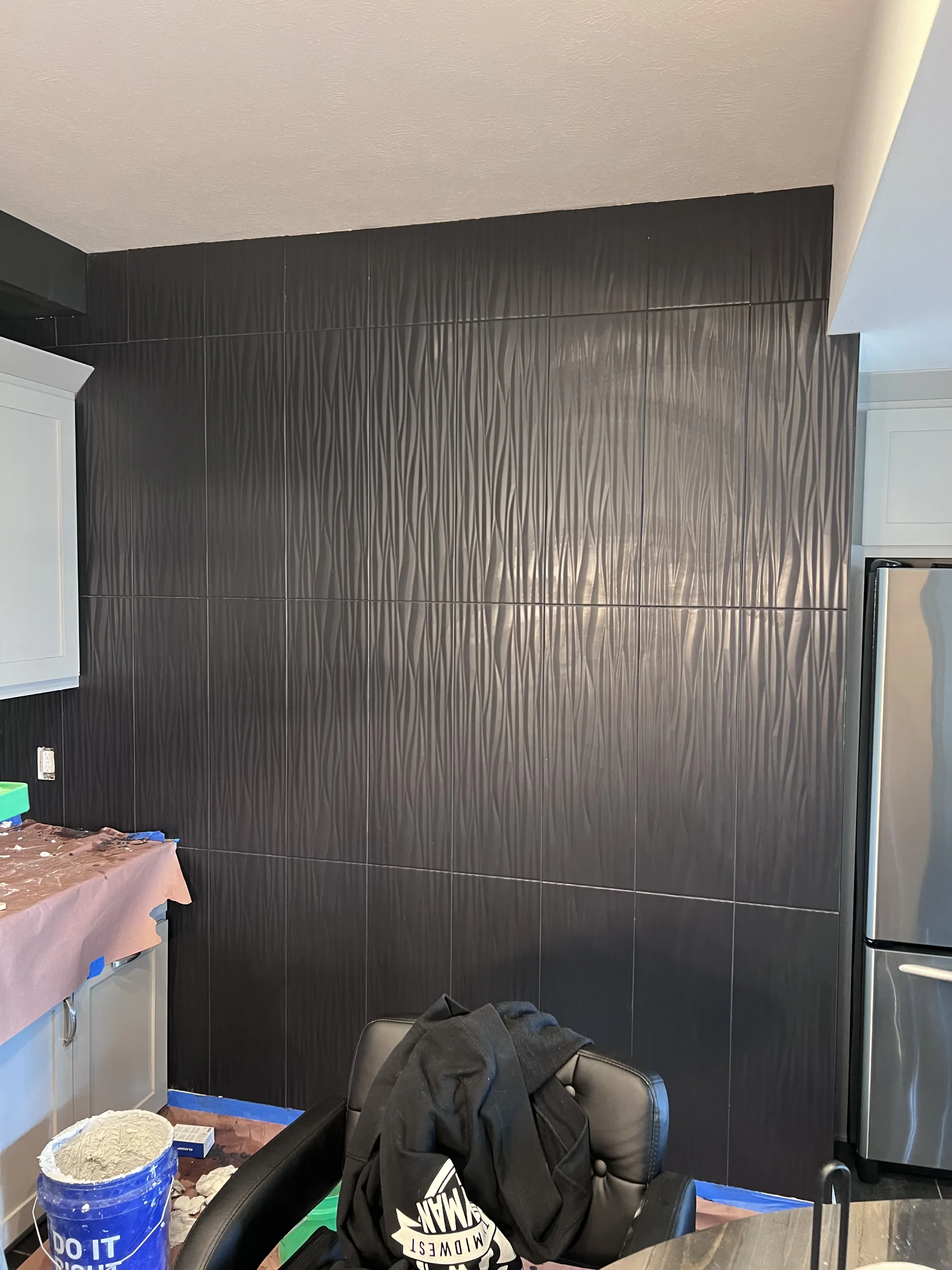 Dramatic black textured tile feature wall in a kitchen