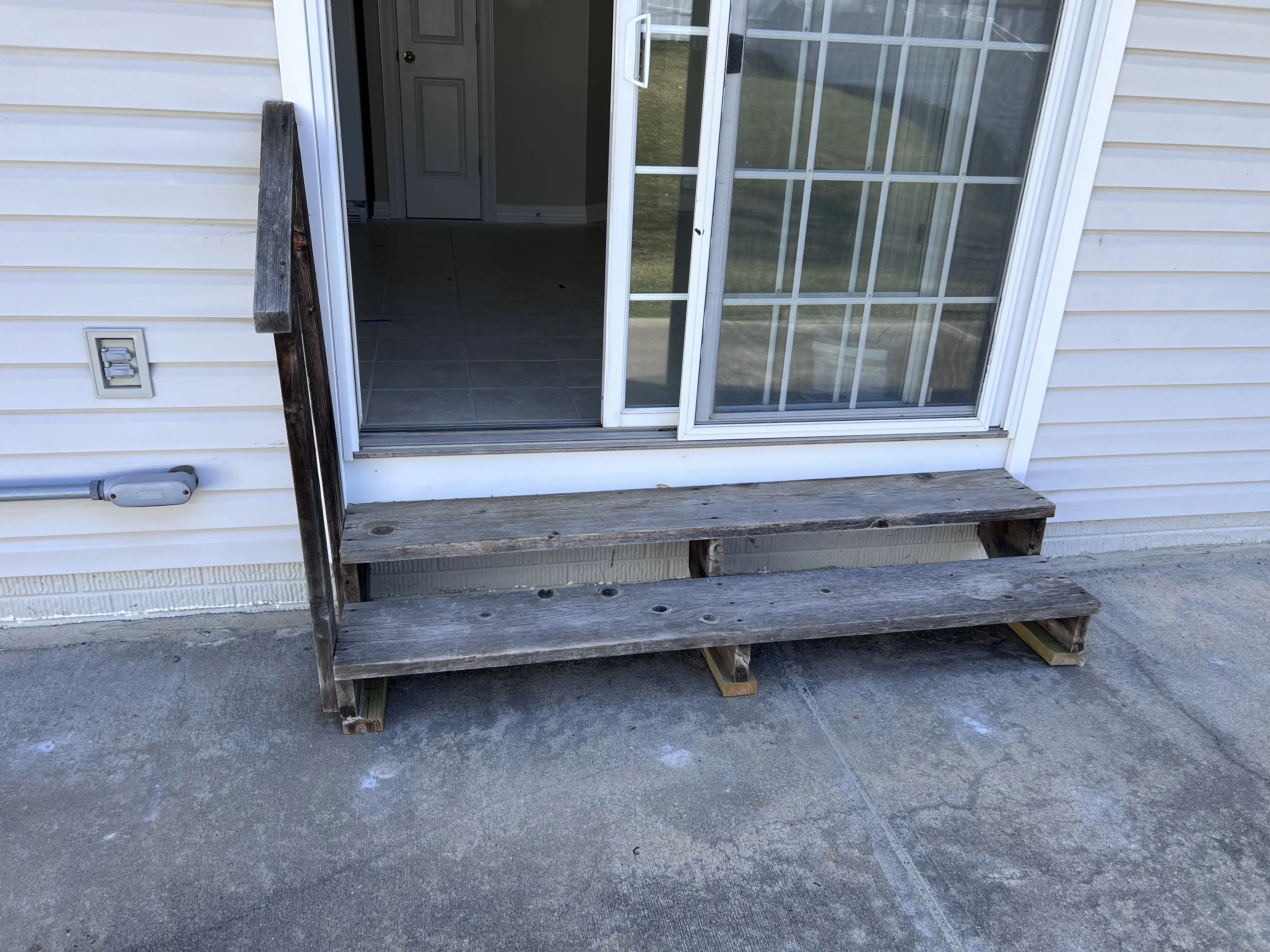 Old weathered wooden steps at a back patio door